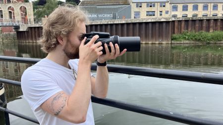 Nikon Coolpix P1100 lifestyle image of Mike Harris holding camera by river 
