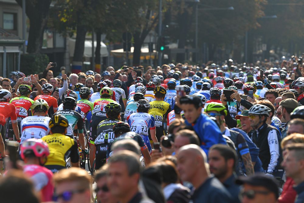 The peloton in and amongst the crowd iduring Il Lombardia