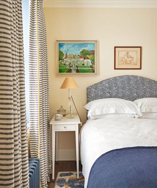 Stripped curtains, white bedside table, blue blanket