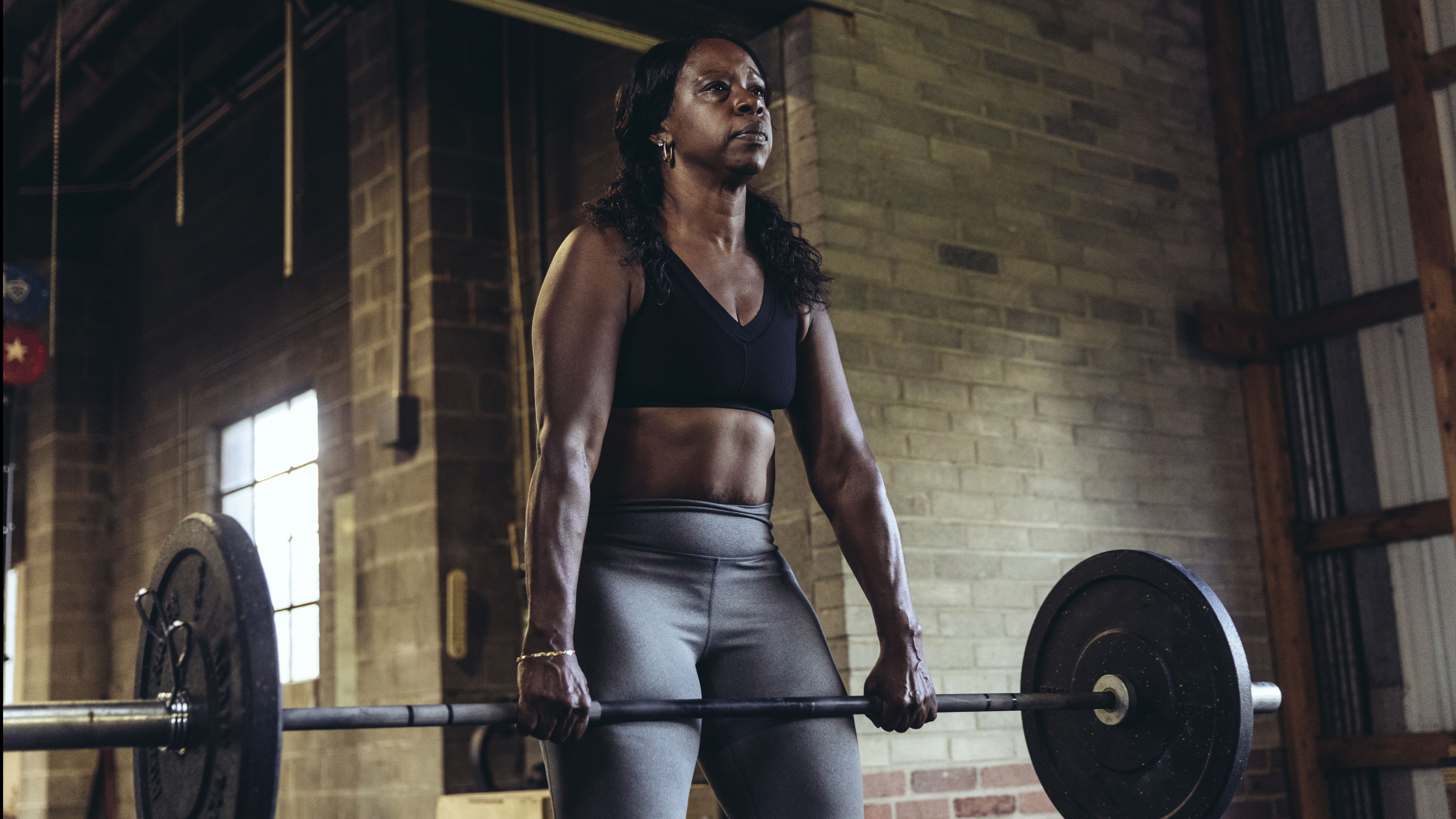 A woman holds a barbell