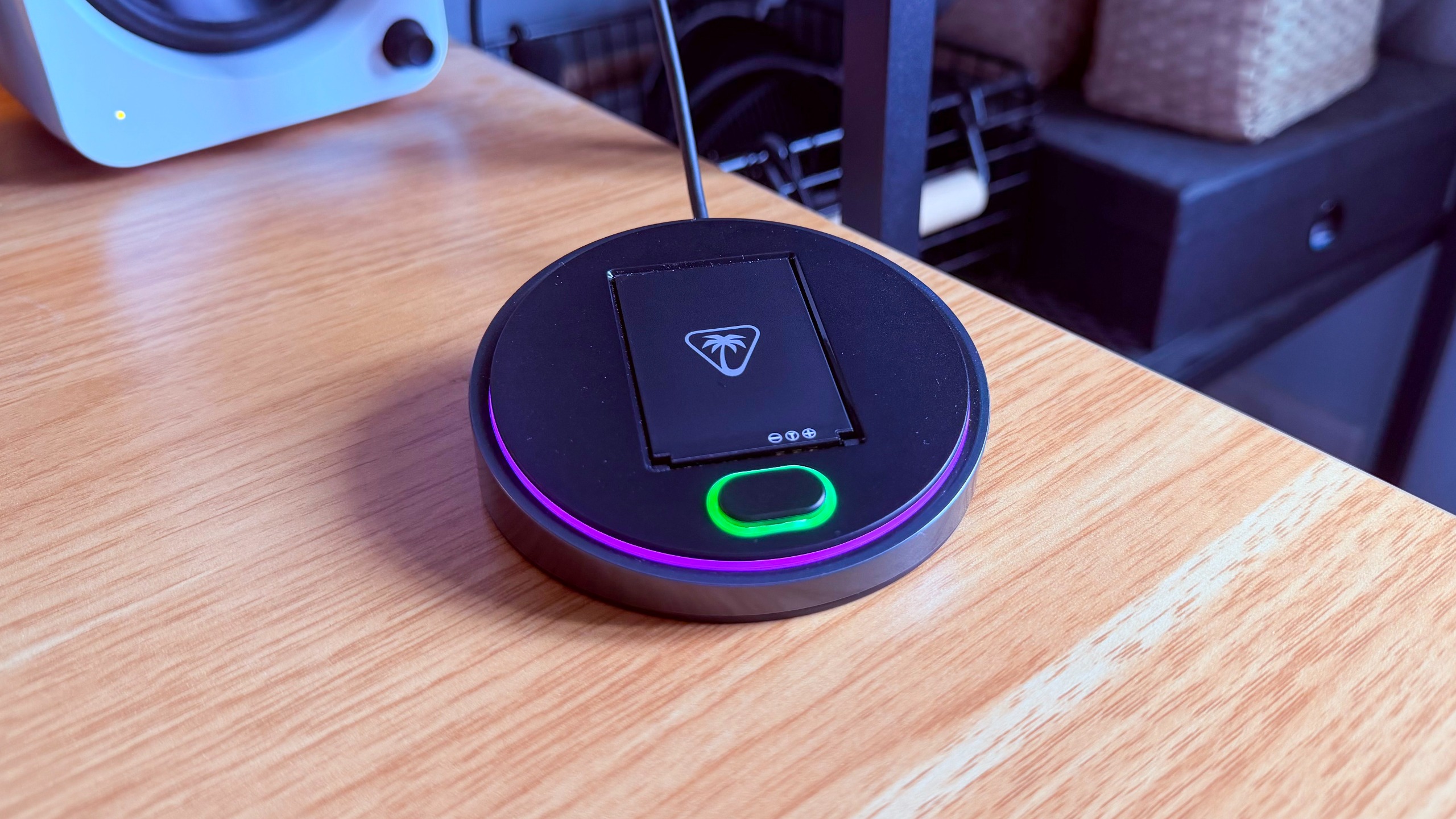The Turtle Beach Stealth Pro II base station with a charging battery and the status lights illuminated purple and green