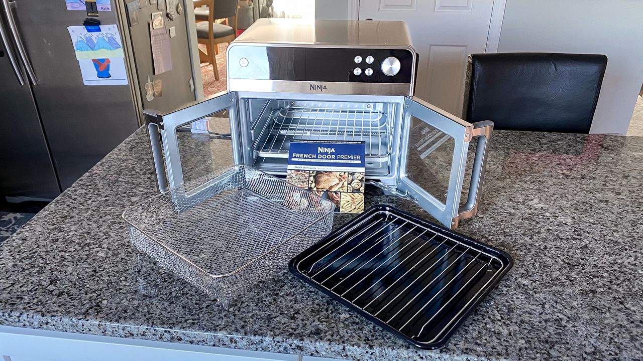 Ninja French Door Premier Air Fryer on a kitchen counter with doors open and accessories