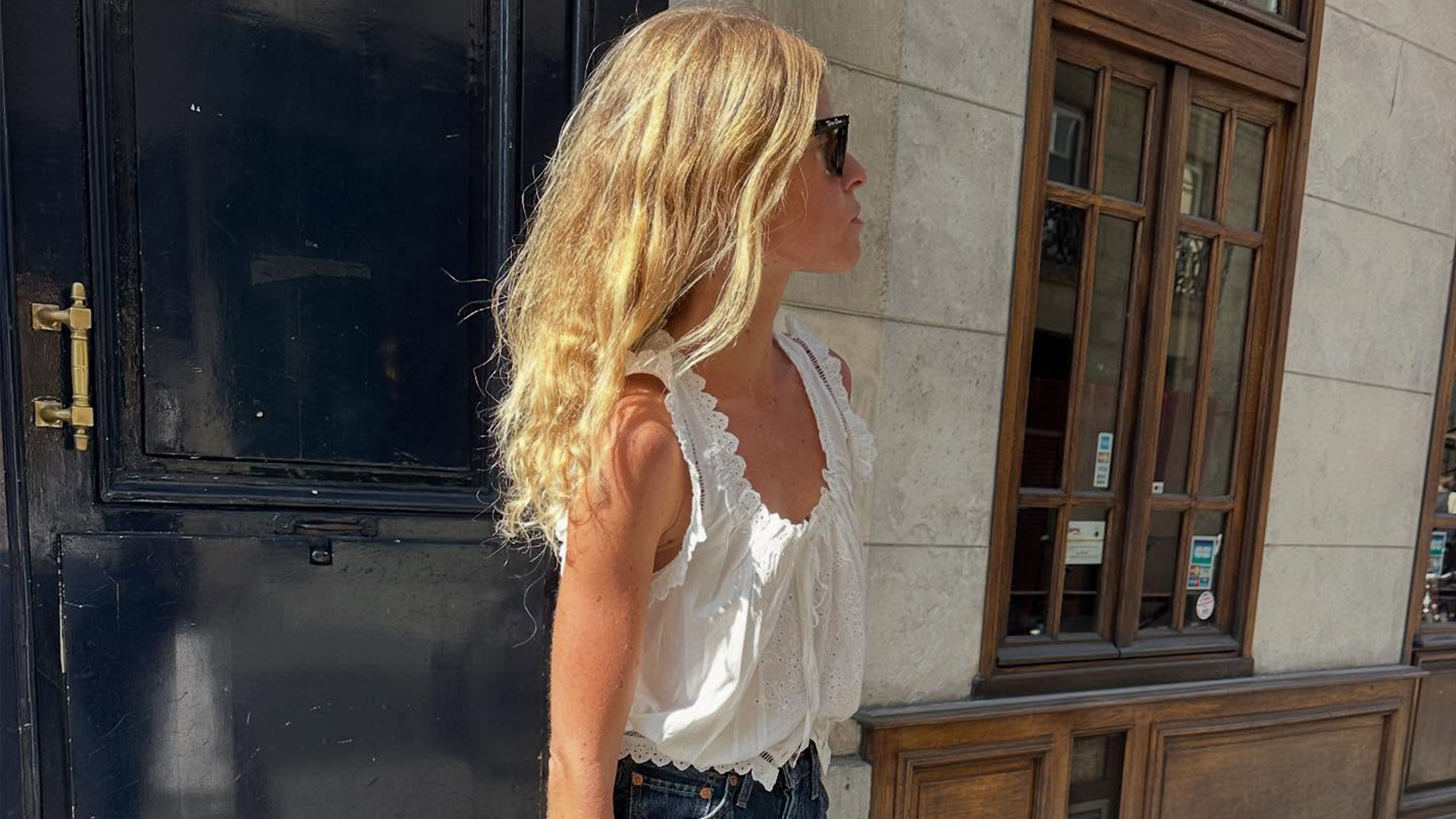 Alice Pilate wearing a Doen embroidered top with jeans and a leather woven tote bag
