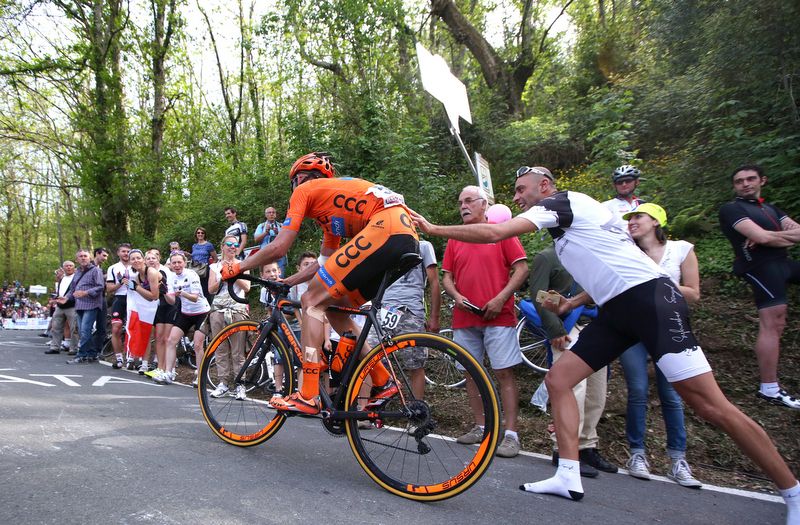 A shoeless fan gives Sylwester Szmyd a push up the climb