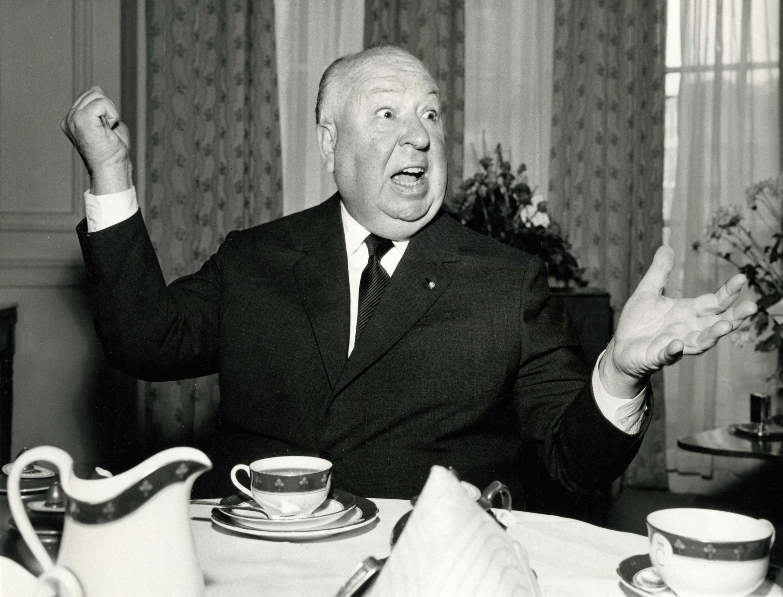 Alfred Hitchcock wields a butter knife while having breakfast at Claridge's