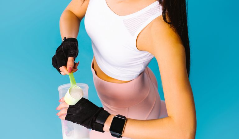 Woman scooping protein powder