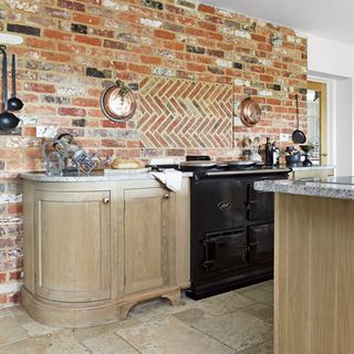kitchen with exposed brick wall and designed brick splashback