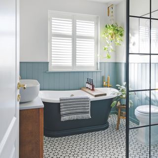 Blue bathroom with blue wood panelling, a blue bathroom, and black and white tiled floor