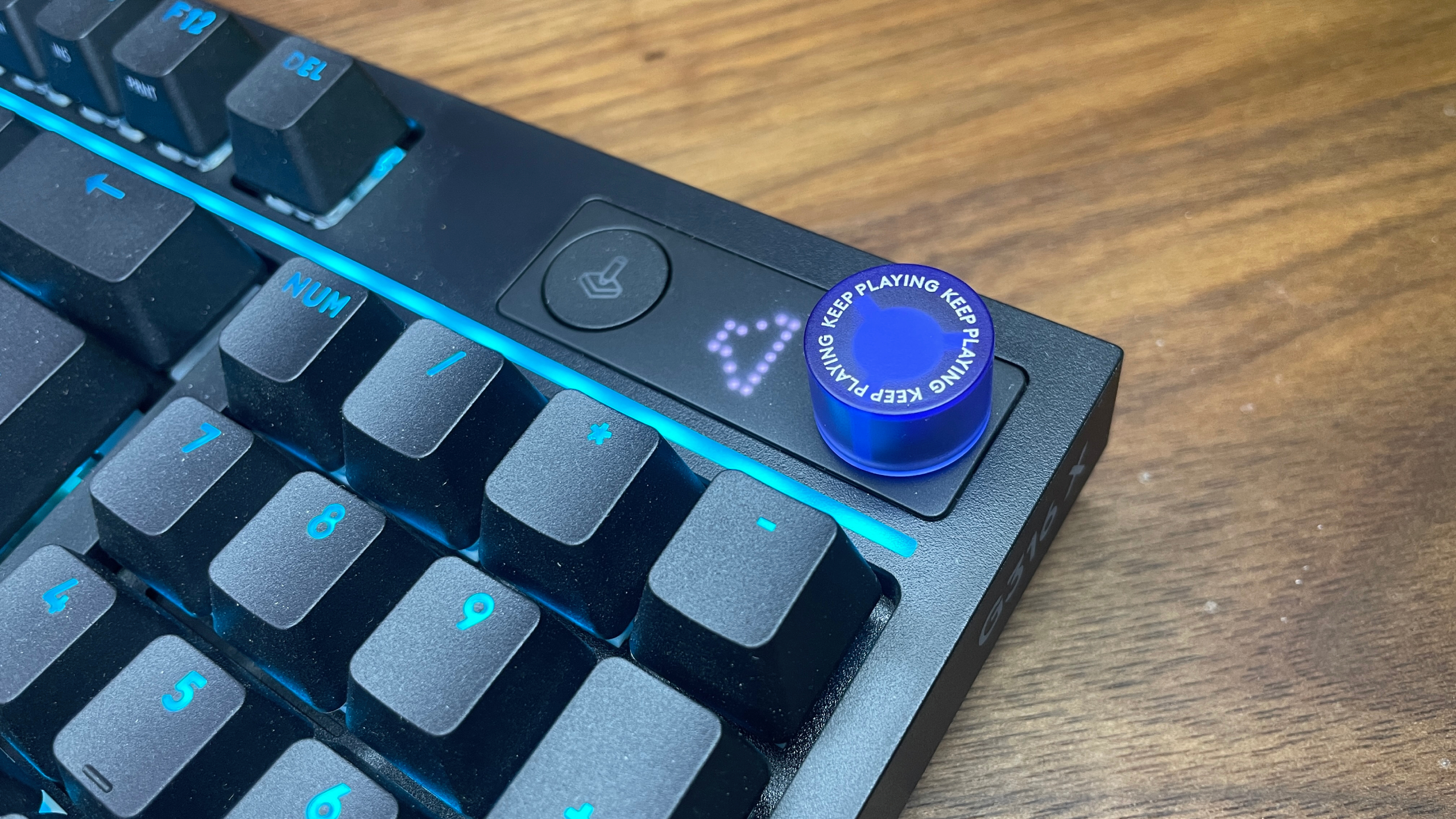 A Logitech G316 X gaming keyboard on a wooden desk.