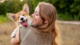 Funny dog jokes - woman holding dog smiling at him