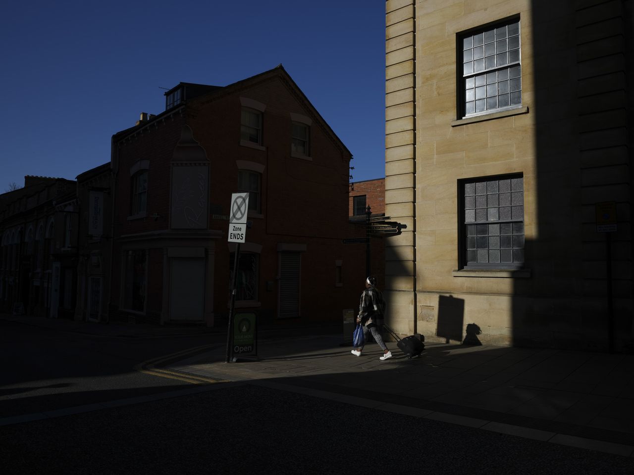 Fujifilm GFX100 RF sample images &ndash; person illuminated by early morning sun in a city, strong shadows