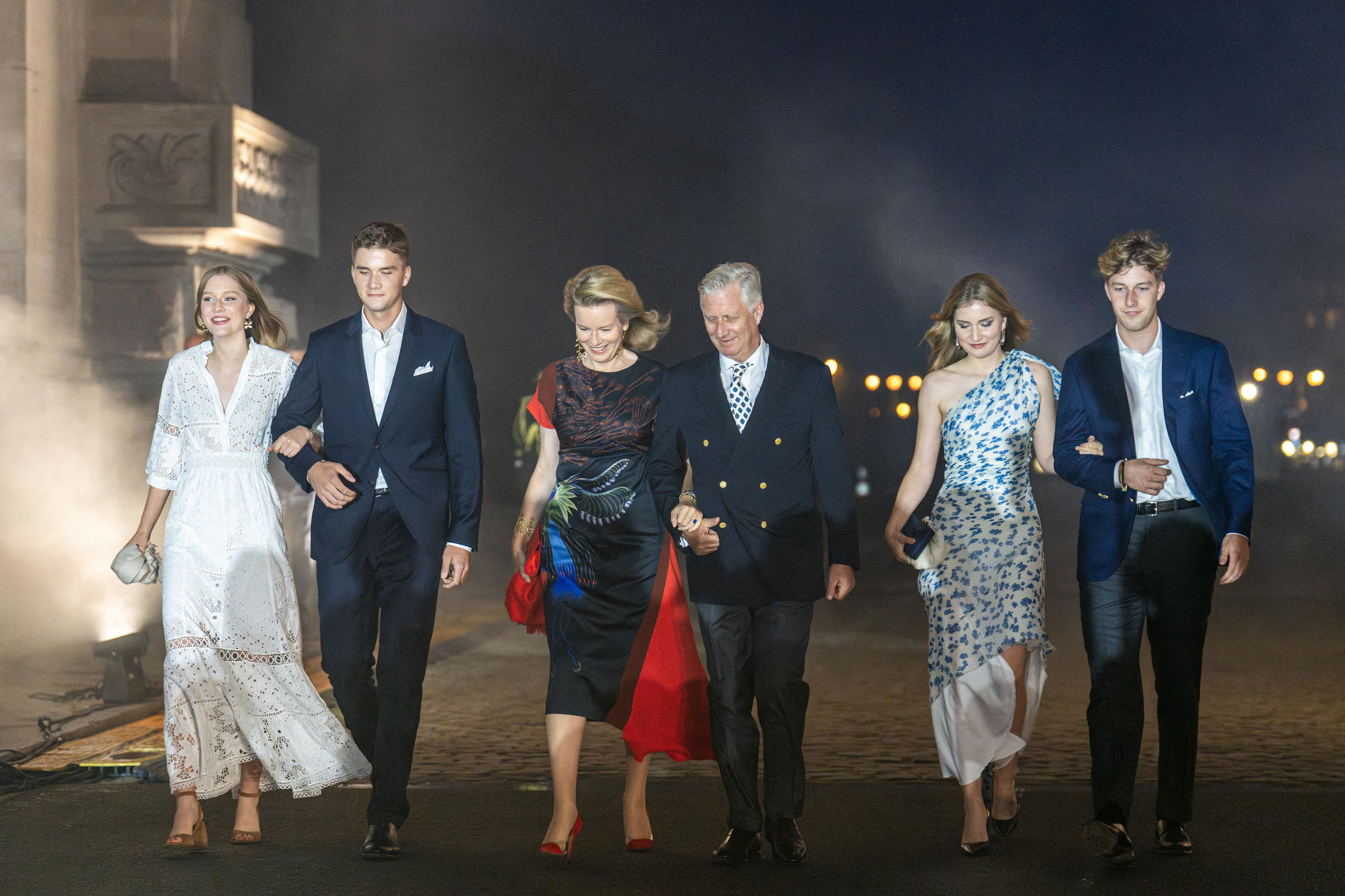 Princess Eleonore, Prince Gabriel, Queen Mathilde of Belgium, King Philippe of Belgium, Crown Princess Elisabeth, Prince Emmanuel walking in a line wearing dresses and suits on National Day