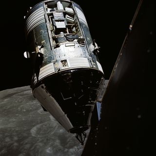 The Apollo 17 Command and Service Modules docked in space with the surface of the moon and large craters visible below.