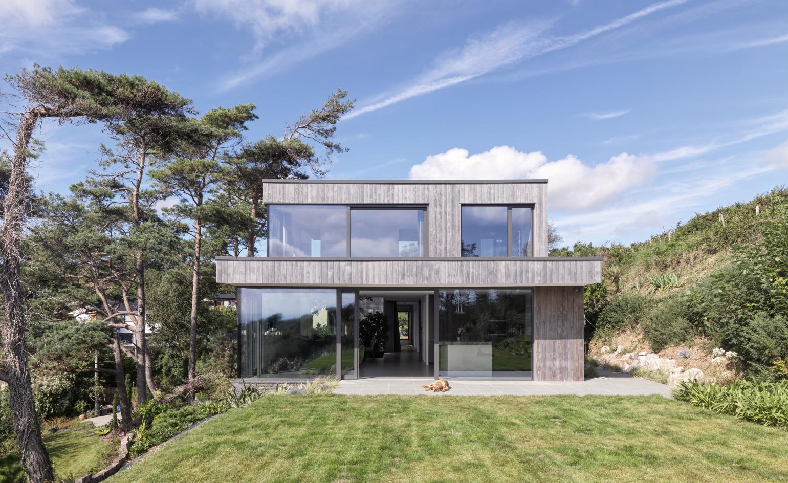 house with front yard lawn and glass windows
