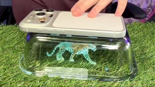 Screenshot of TikTok video showing DIY hologram projector using your phone and a rectangular glass dish.
