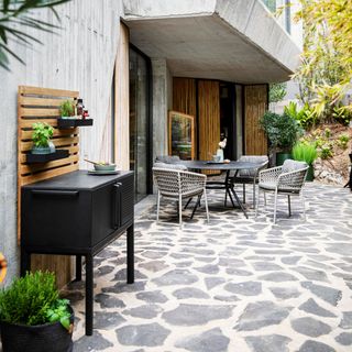 outdoor dinning table and chair stone flooring and black counter cabinet