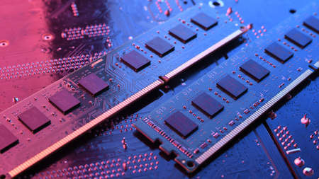 A dramatically lit close up of computer memory/ RAM on a motherboard-style background.