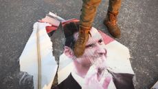 Rebel fighter steps on torn photo of Syria's deposed Bashar al-Assad