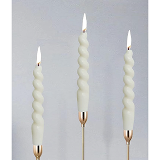 three white twisted candlesticks in gold holders