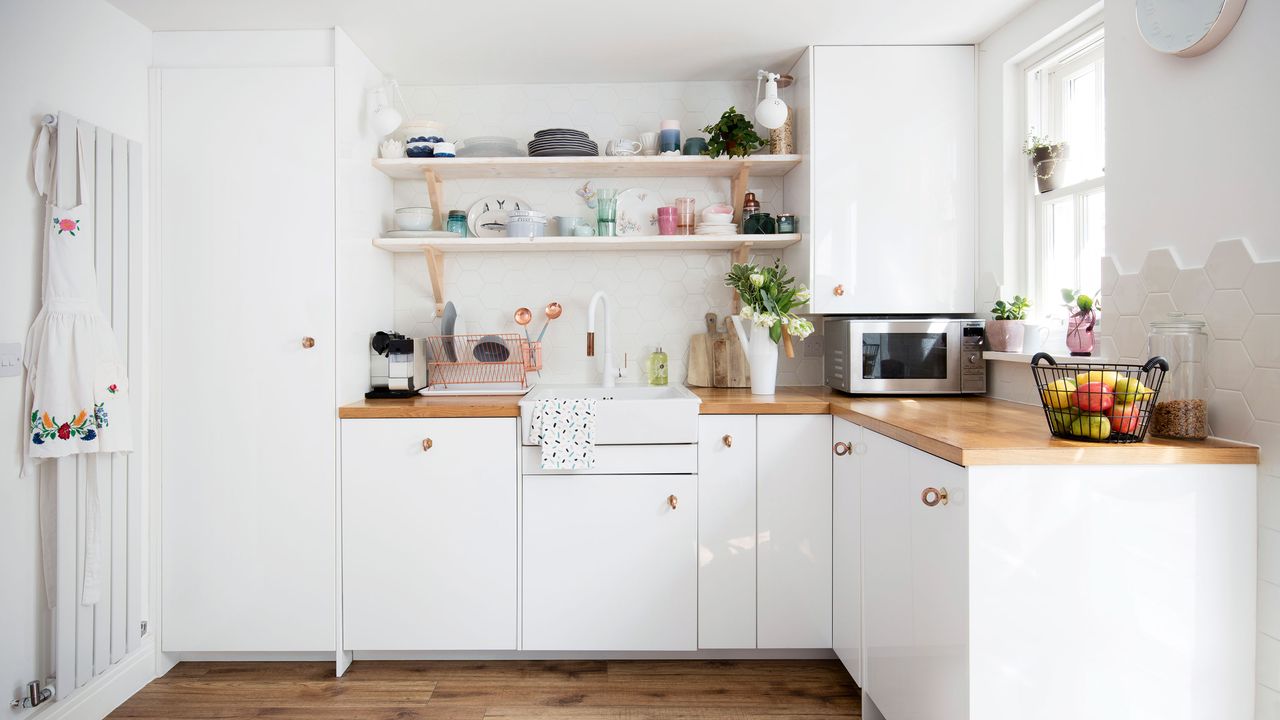 L-shaped white kitchen with wood worktops and white wall tiles