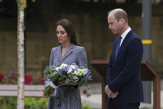 Catherine, Duchess Of Cambridge lays flowers as she and her husband Prince William, Duke of Cambridge attend the launch of the Glade of Light Memorial garden