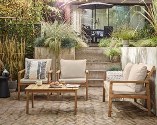 patio with sofas surrounded by planters filled with ornamental grasses