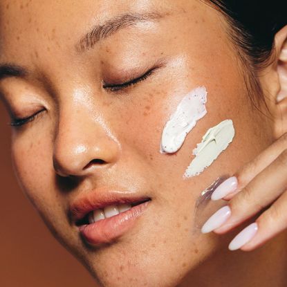 woman with beauty creams on her cheek