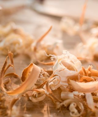 A light wooden table with light and rich brown curled wood shavings on top of it