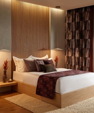 modern bedroom with slatted wall panel behind bed, rich maroon curtains and runner on wooden frame bed
