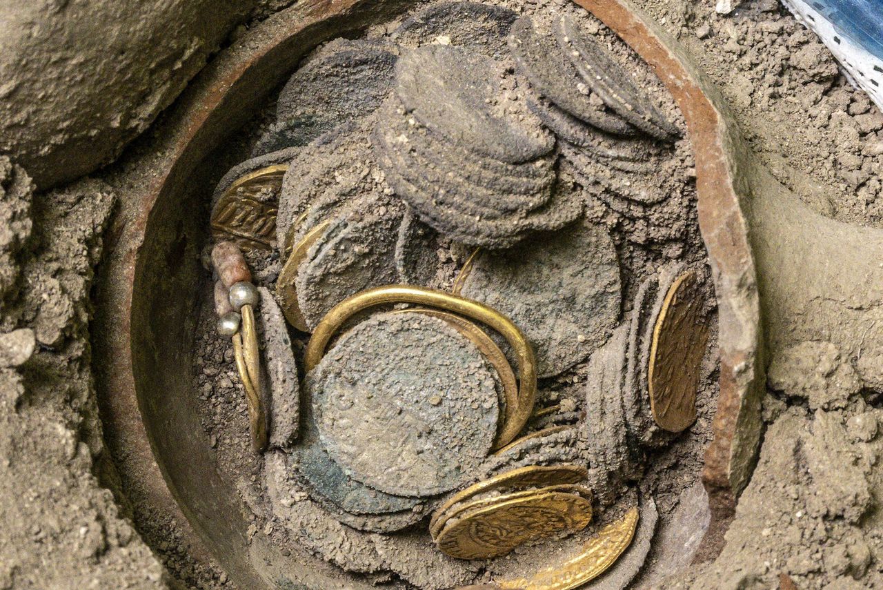 a coin hoard in a pot in the dirt