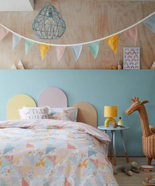girls bedroom with scalloped headboard, bunting and divided wall