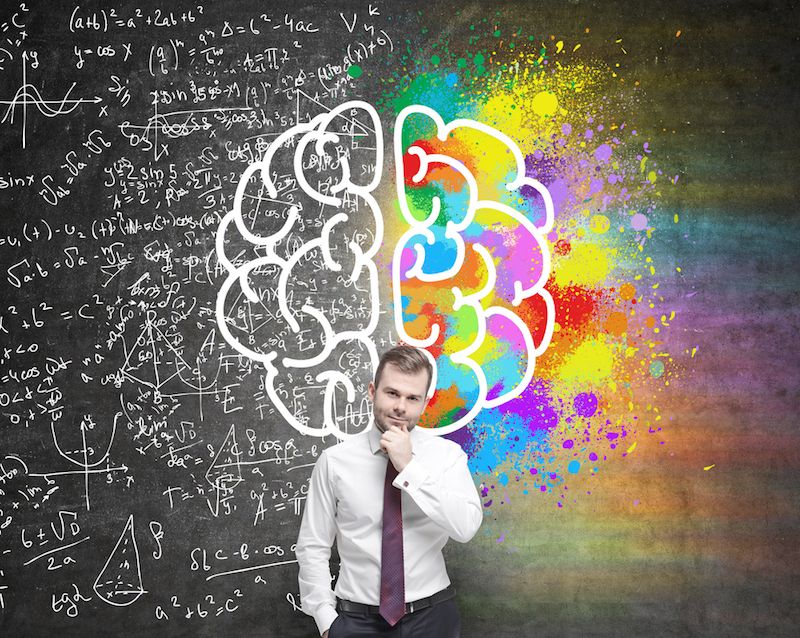 A man stands in front of a drawing representing the 2 halves of the brain.