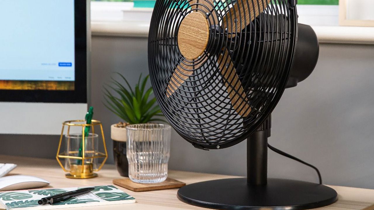 russell hobbs scandi wood effect desk fan on a desk with a computer