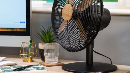 russell hobbs scandi wood effect desk fan on a desk with a computer