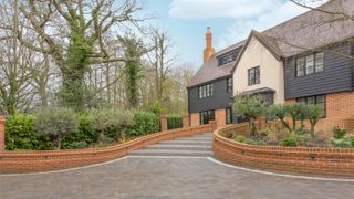 sweeping block paved driveway leading to house, with steps, retaining front garden walls in red brick