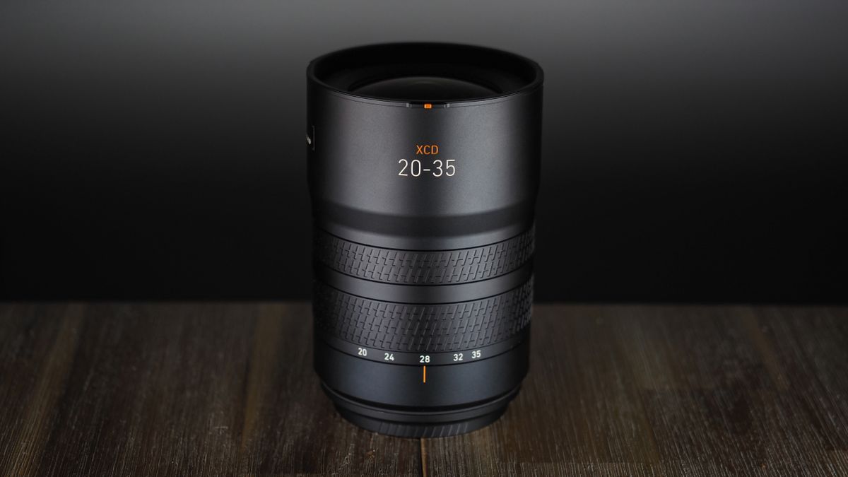Hasselblad XCD 20-35E lens, moodily lit with subdued lighting, on a wooden surface