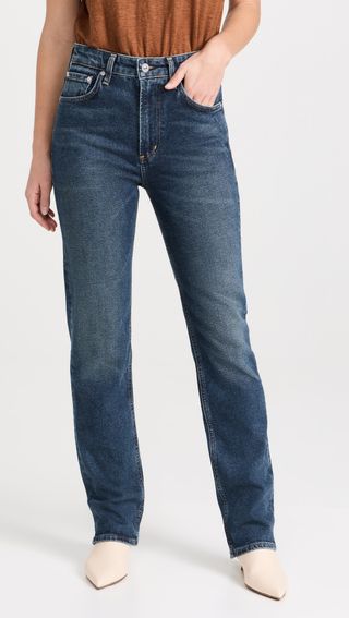 a model wears straight-leg dark-wash blue jeans
