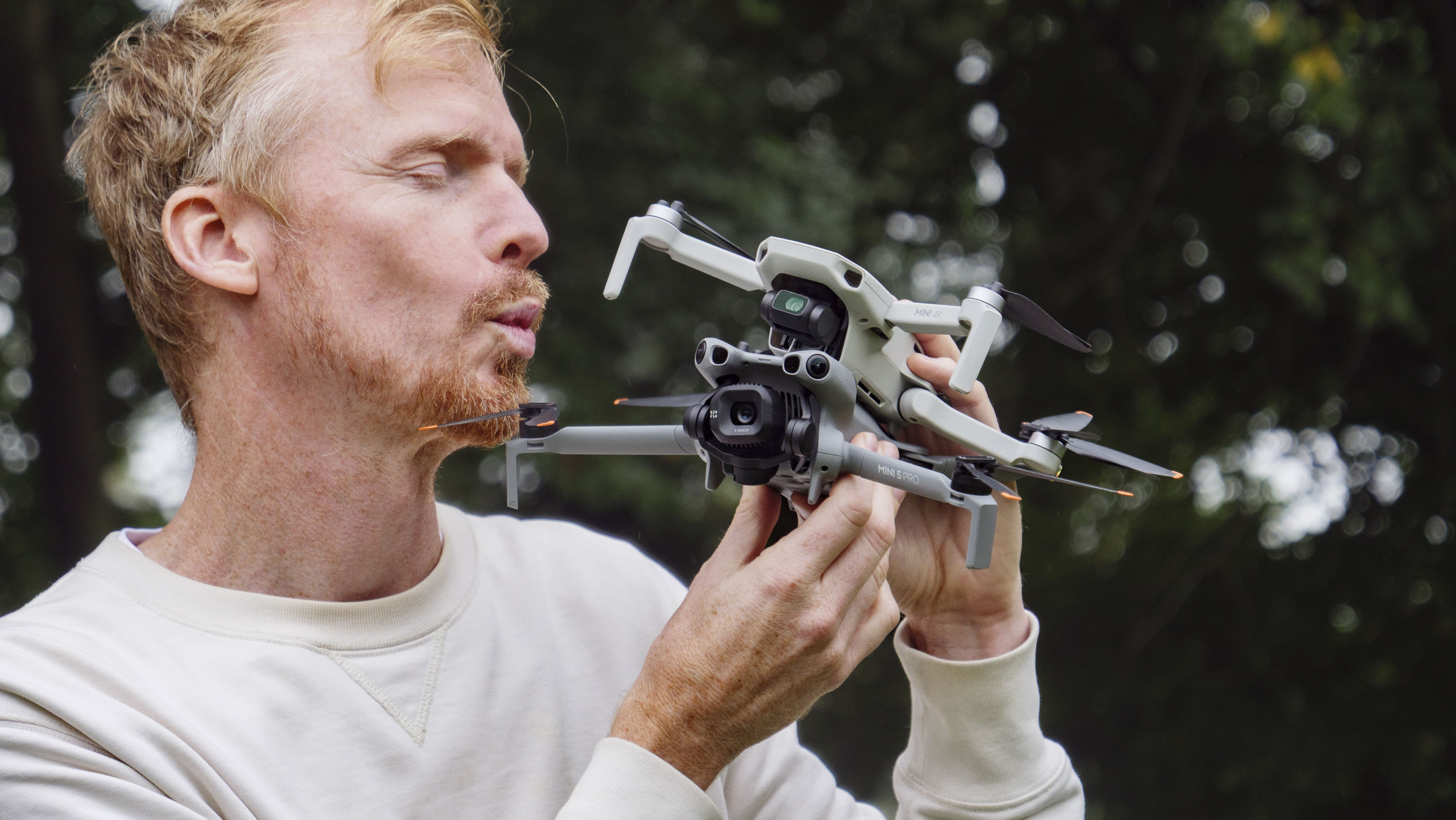 DJI Mini 5 Pro and DJI Mini 4K drones held by side by side