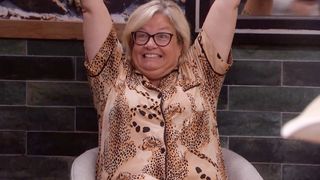 Angela throwing her hands up and celebrating. 