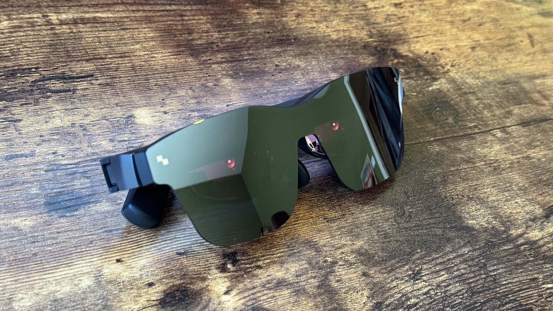 The TCL RayNeo Air 2 smart glasses on steel and wooden surfaces
