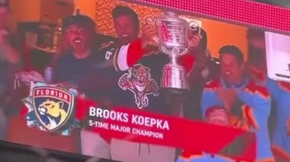 Brooks Koepka lifts the Wanamaker Trophy at a Florida Panthers game