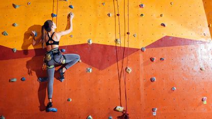 A woman scaling an artificial rock climbing wall