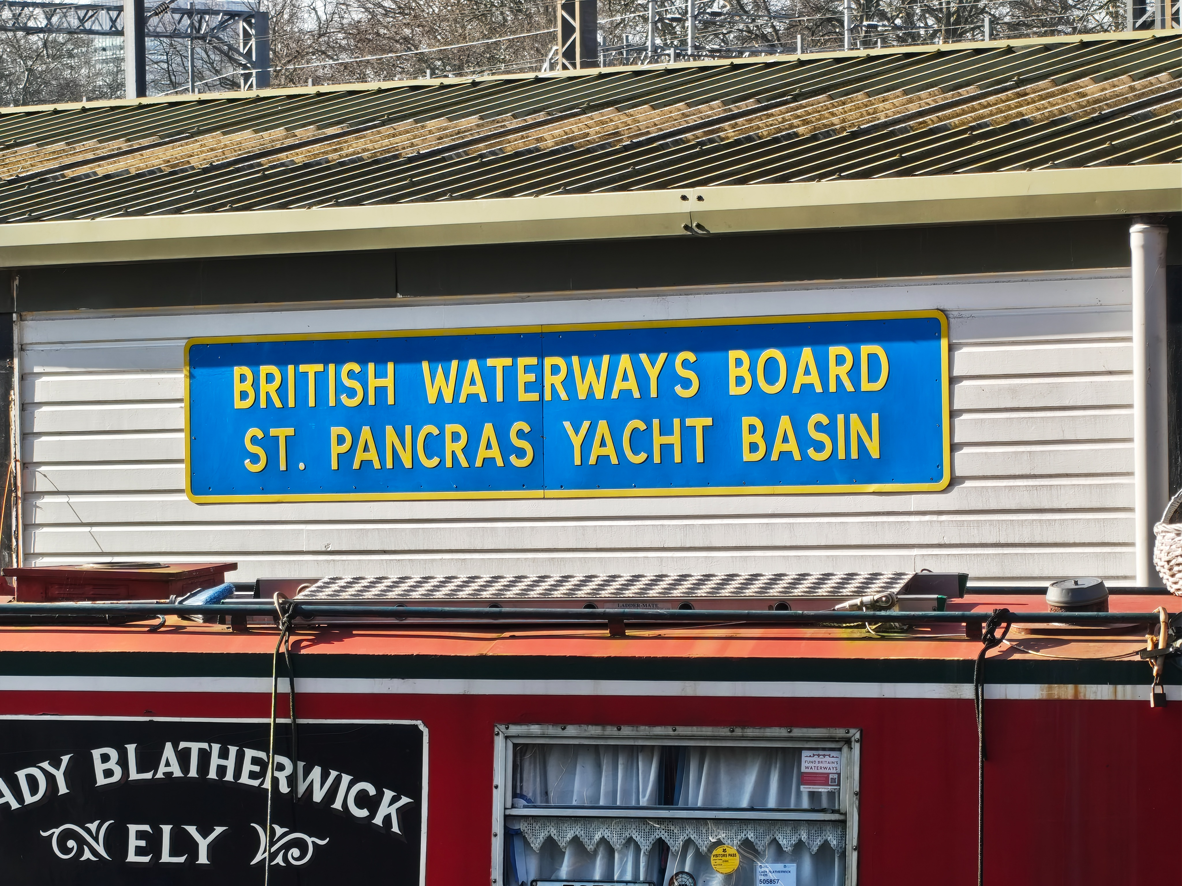 Sign reading &ldquo;British Waterways Board St. Pancras Yacht Basin&rdquo; mounted above a canal boat, photographed with the Nothing Phone (4a).