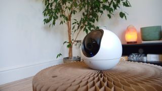 Image shows the Ezviz C6 home camera inside a living room.