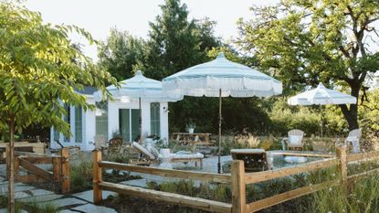 backyard with plunge pool, lounge chairs and sun umbrellas