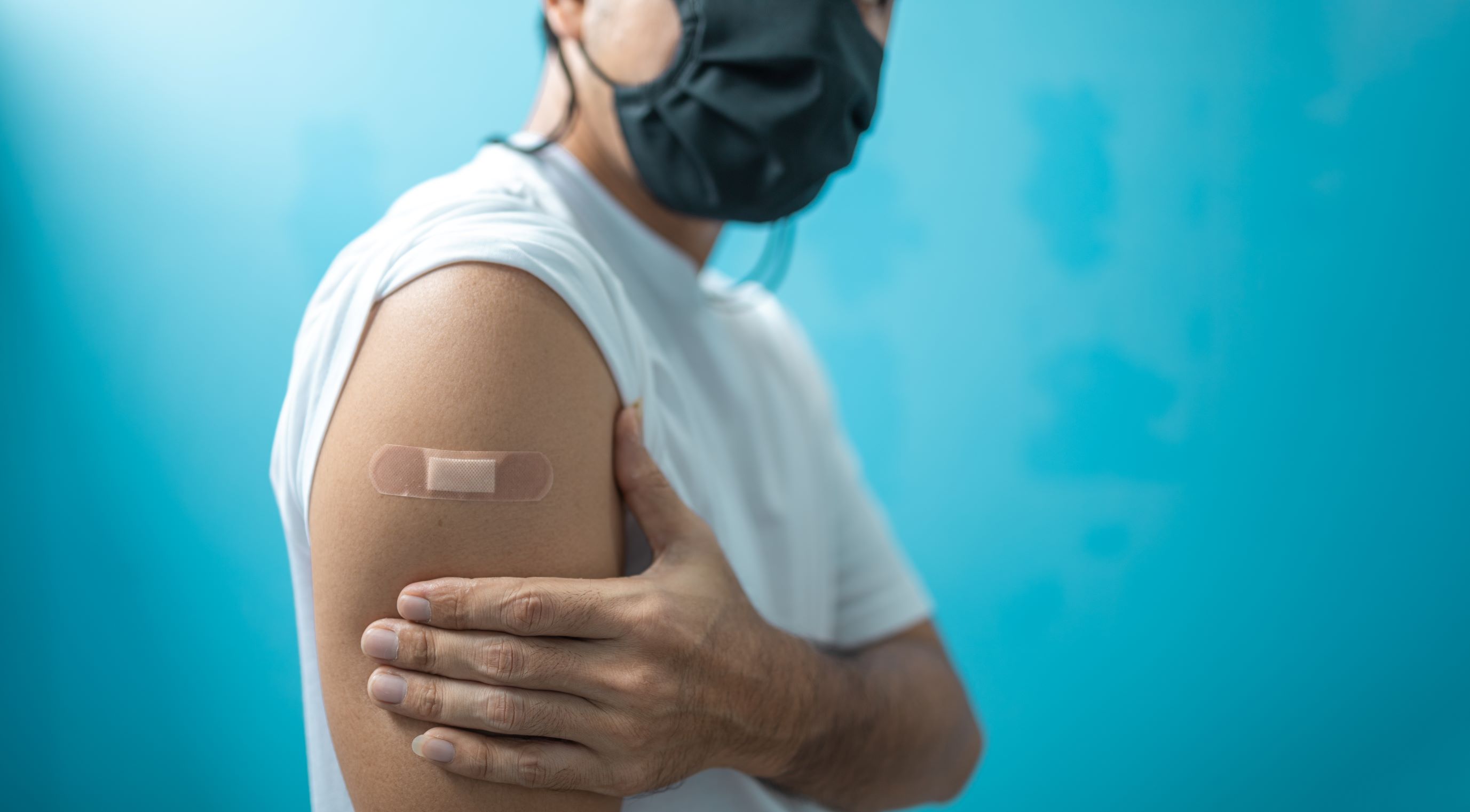 A person holding their arm after a flu shot.