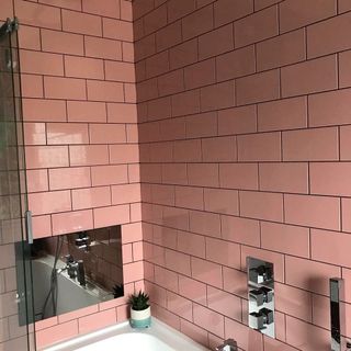 Bathroom with pink tiles and mirror on wall