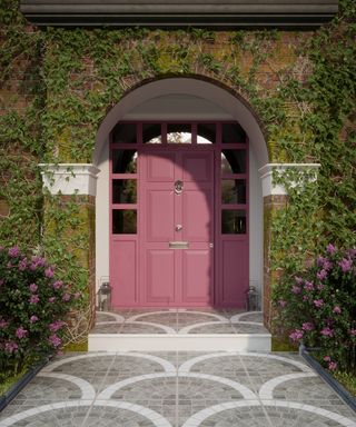 Front porch ideas showing a Sampietrini pavement leading up to a pink front door set into an archway