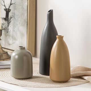 three neutral toned vases of different heights with a curved shape