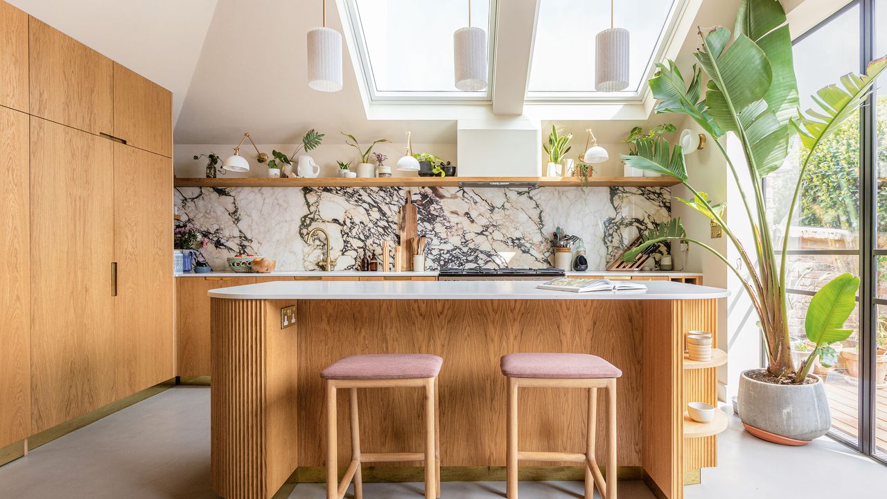 Light and bright kitchen with wood panelled island and patterned marble splashbacks